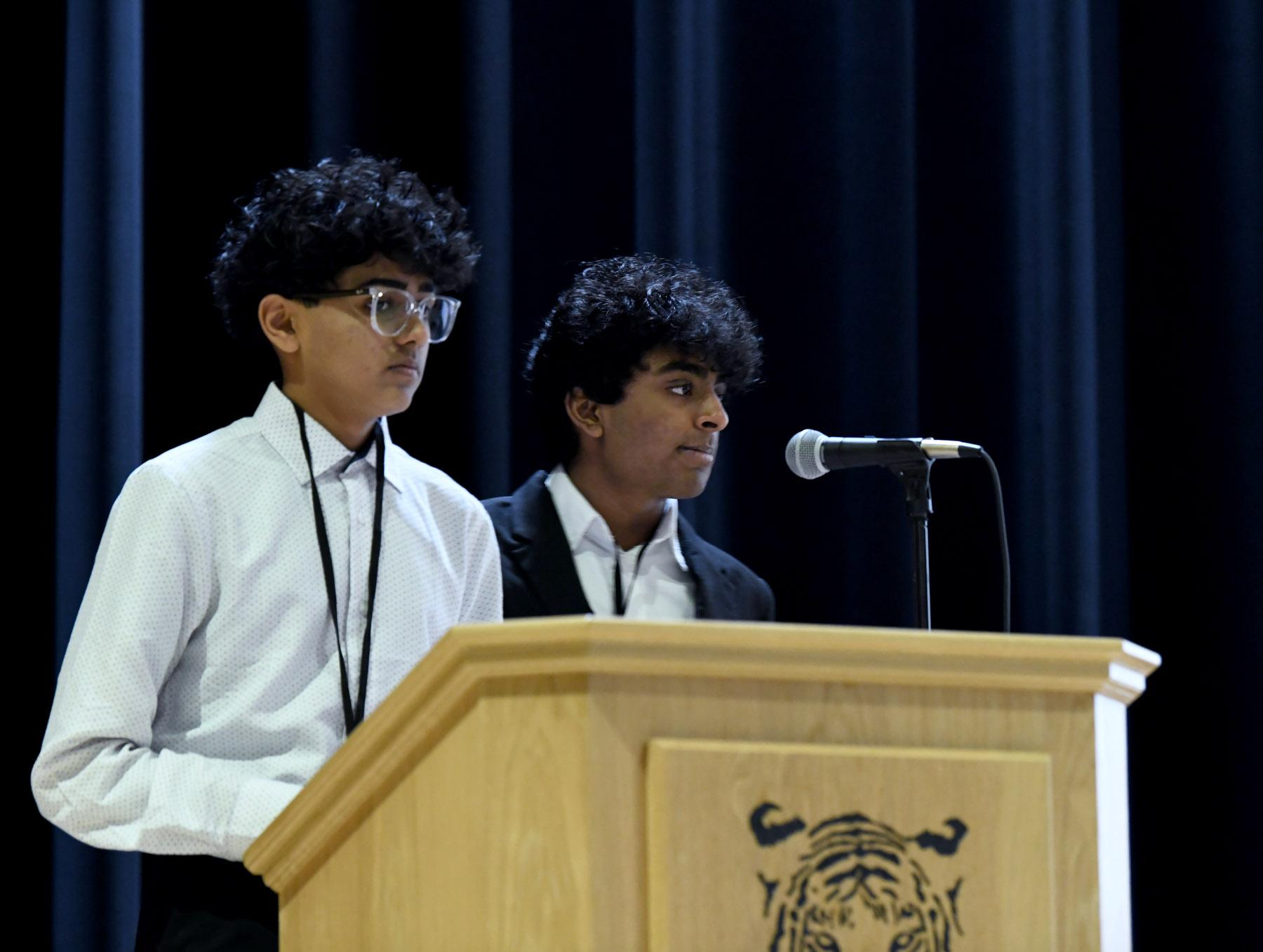 Two Moody students speaking from a podium