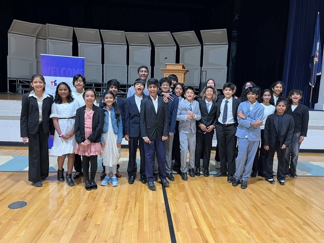 Moody debate students gathered on an auditorium stage