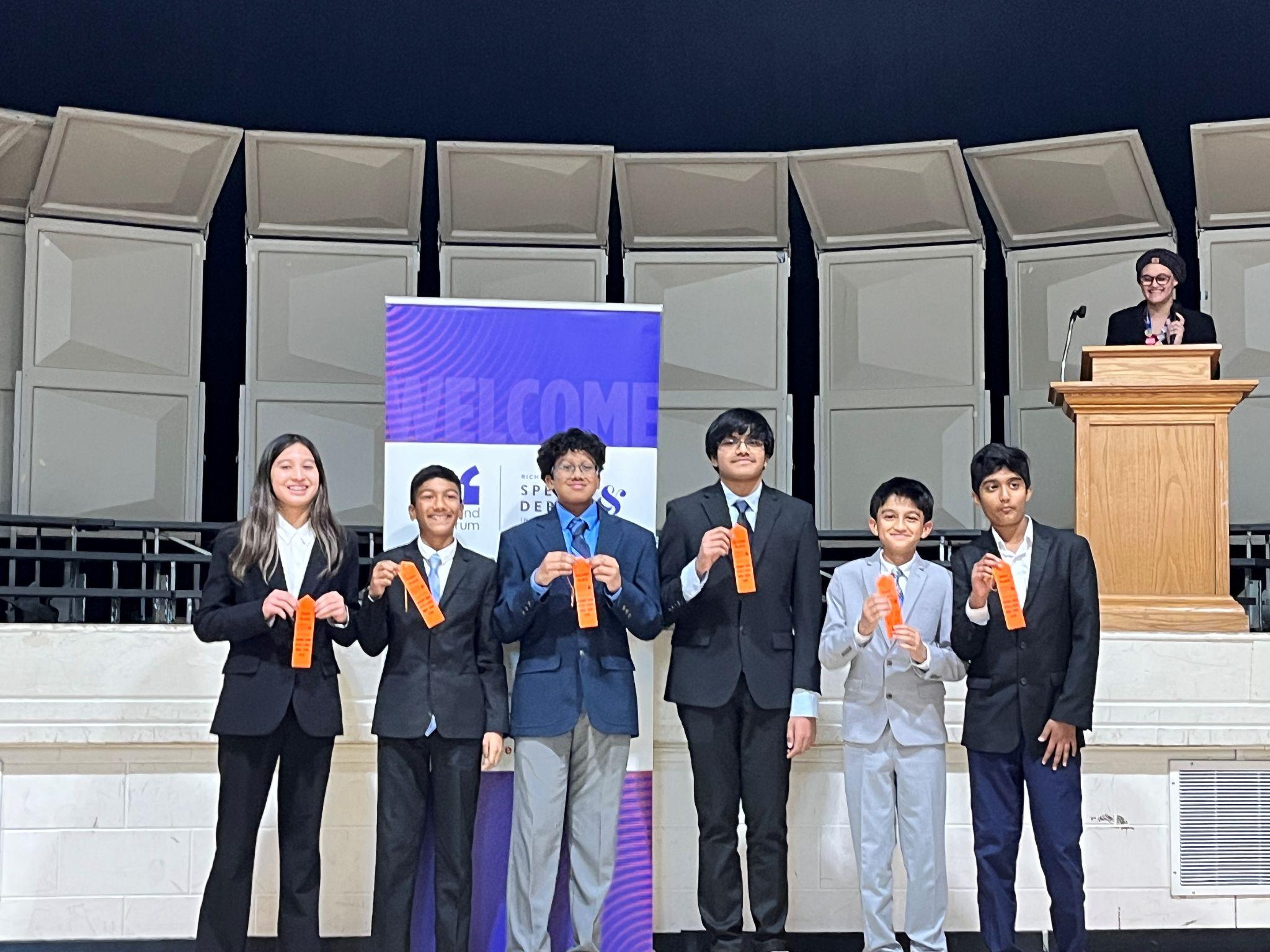 Moody debate students holding tournament ribbons